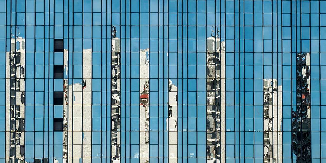 skyscrapers reflected in the glass windows of a smart building