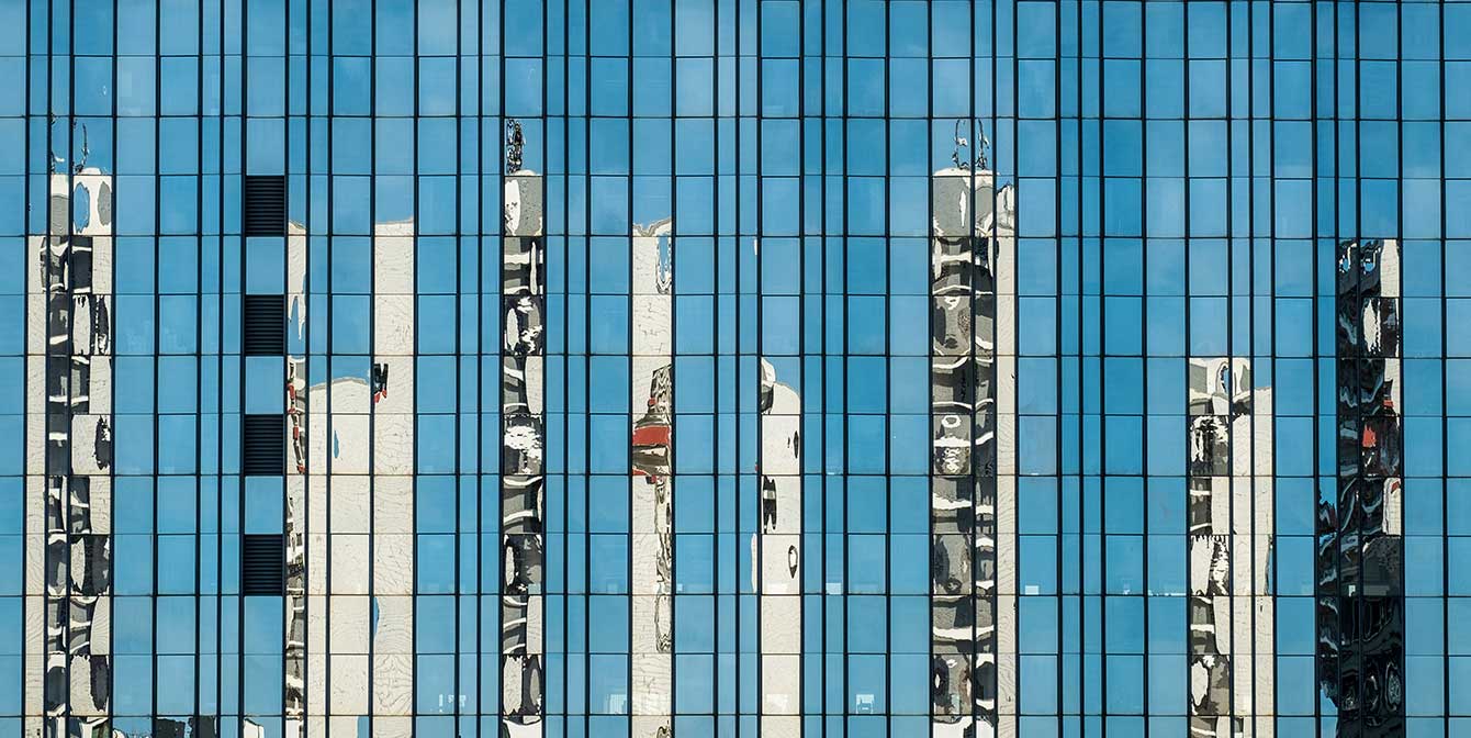 Smart buidlings | JLL Technologies skyscrapers reflected in the glass windows of a smart building