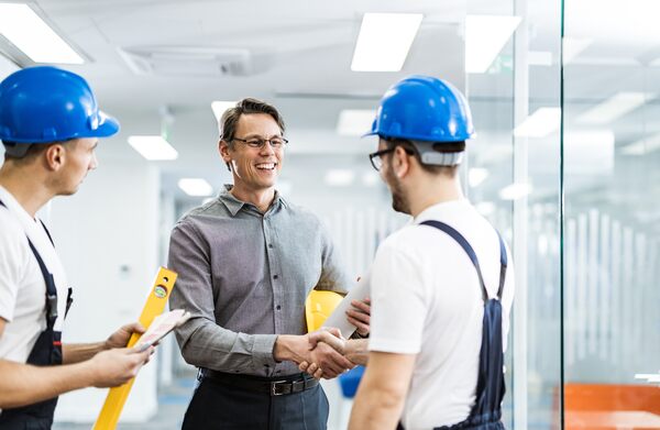 Real Estate Facilities Manager shakes hand with new service provider after fulfilling a service work order.
