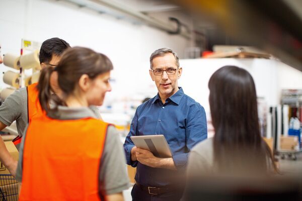 Facility operations leader discusses the day’s work with a team of internal service technicians
