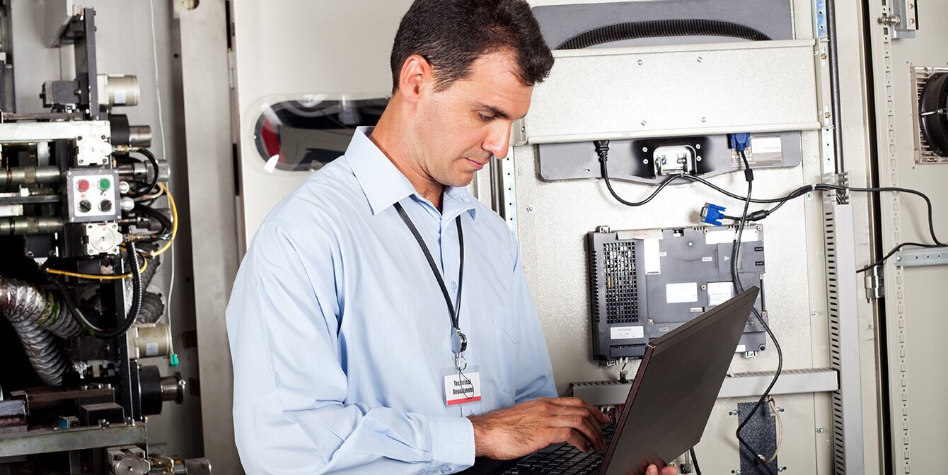 facilities manager with laptop calibrates equipment