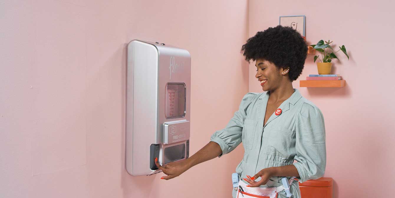 black woman using a free vend period products dispenser