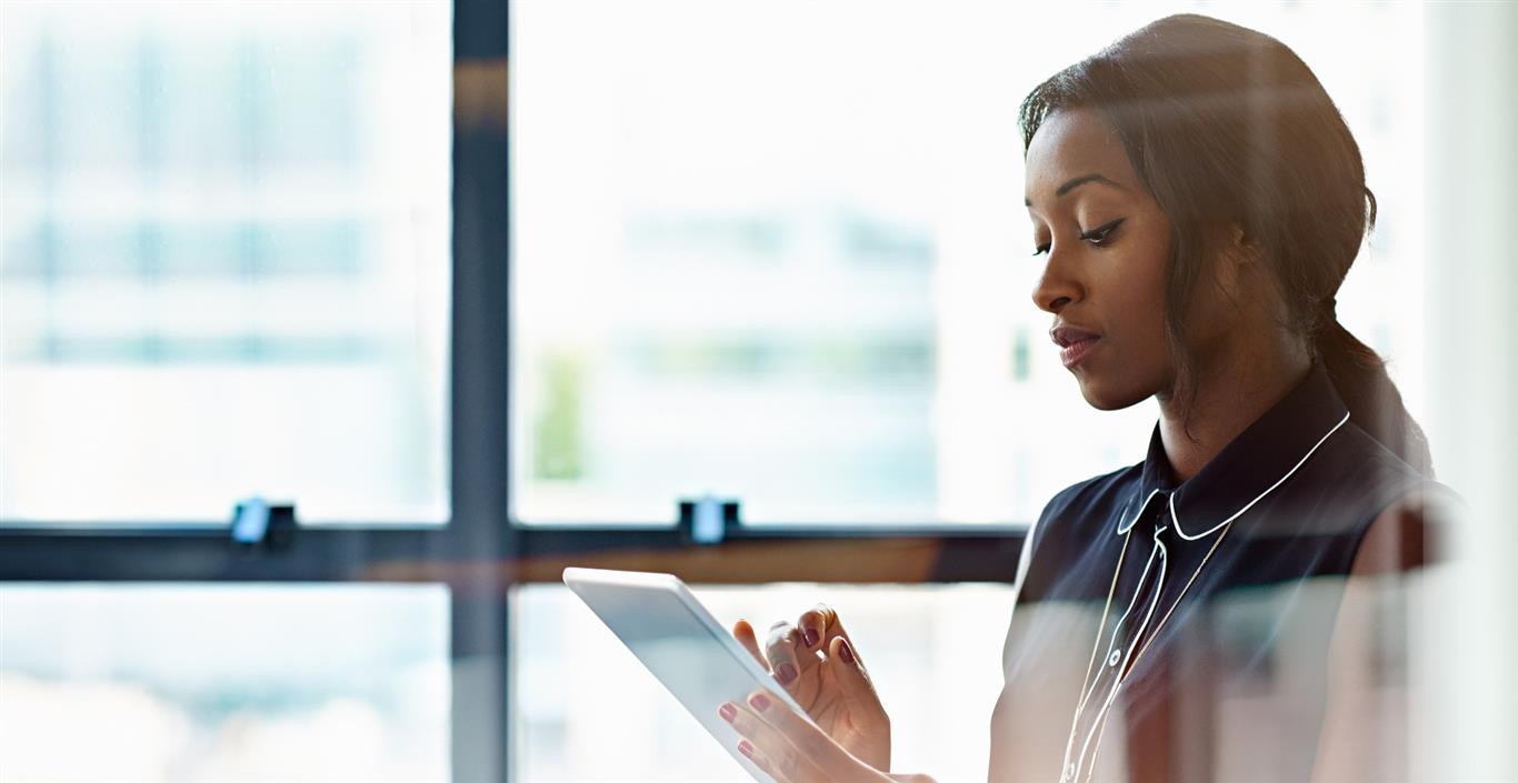 CREtechpitfallstoavoid | JLL Technologies a business woman looks seriously at her tablet in an office building
