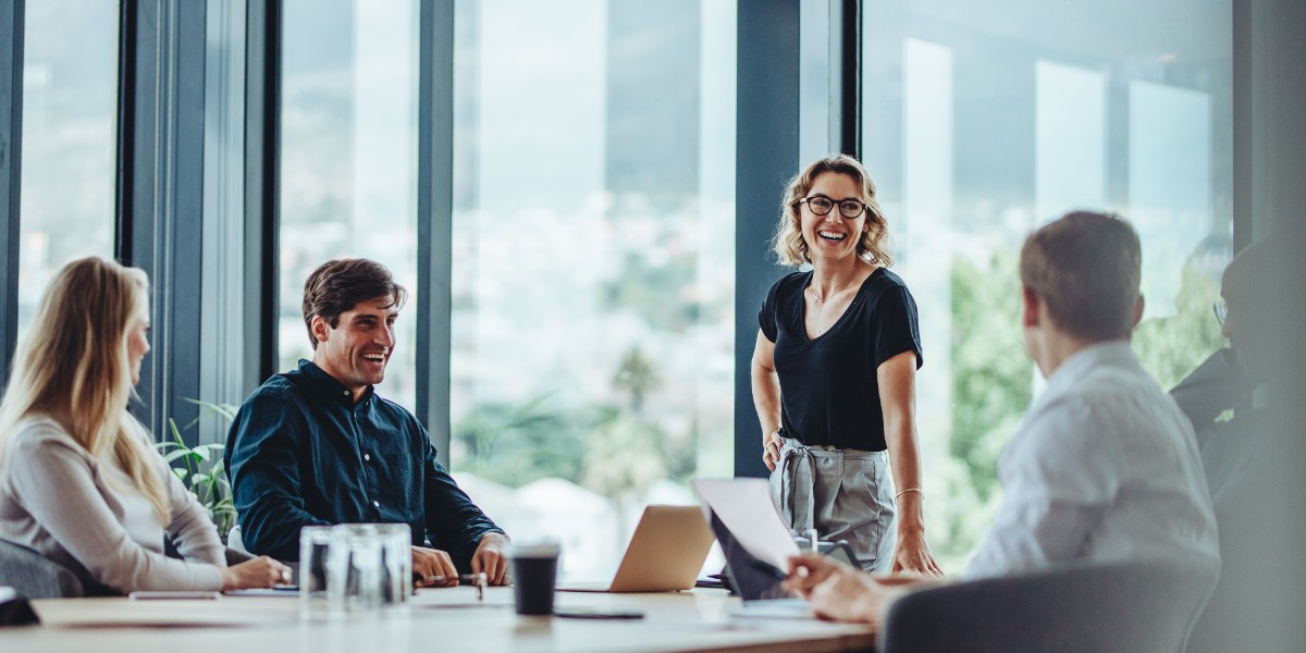 metrics that matter report | JLL Technologies business women and men meet around a conference room table to discuss metrics that matter