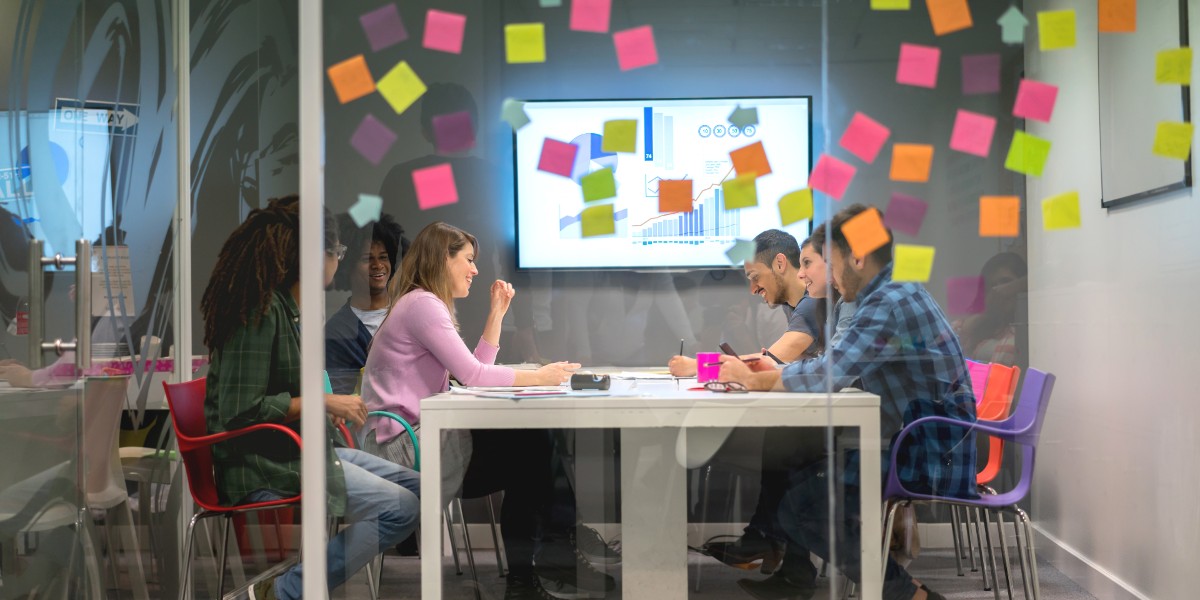 datareadinessformetricsthatmatter | JLL Technologies team sits in conference room with data and metrics on whiteboard and post its on glass wall